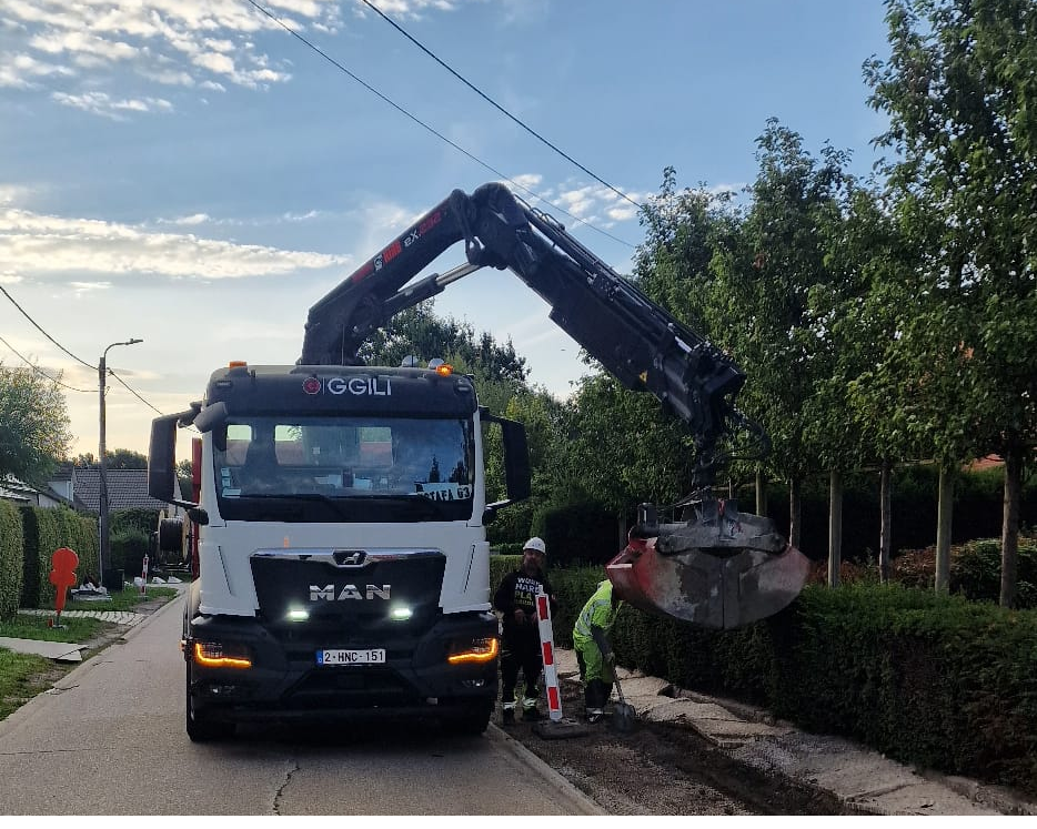 GGILI-MAN-kraanwagen met werfmedewerkers bij nutswerken in een woonwijk